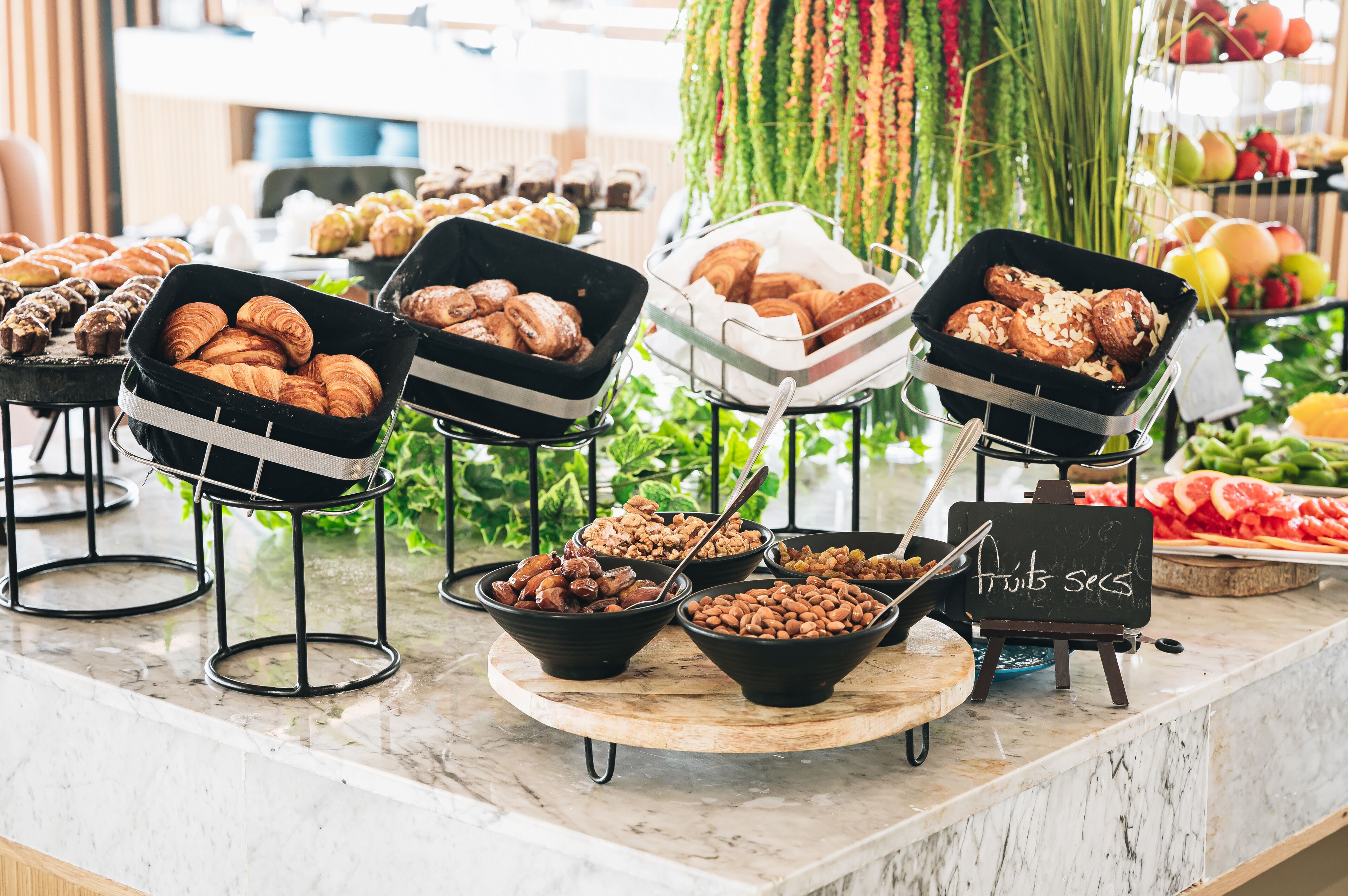 Een buffet met diverse etenswaren, zoals gebak, noten en fruit.
