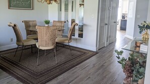A dining area with wicker chairs, a chandelier, and a mirror. - St. Pete Beach / Isla Del Sol -  2 bedroom 2 bath Condo (St. Petersburg)