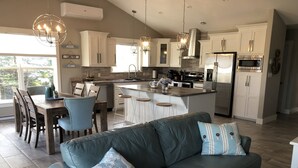 Una cocina moderna con gabinetes blancos, electrodomésticos de acero inoxidable y una isla central.