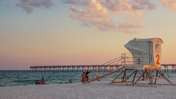 A lifeguard tower with a number 2 sign, a pier extending into the sea, and people on the beach. - Private Pensacola Getaway Minutes to Perdido Key! (Pensacola)