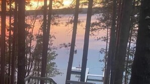 A wooden dock extending into a forested lake area. - Lakefront Whitefish Chain Retreat - Sleeps 15 - Pontoon - Fall Getaway & Rates (Crosslake)