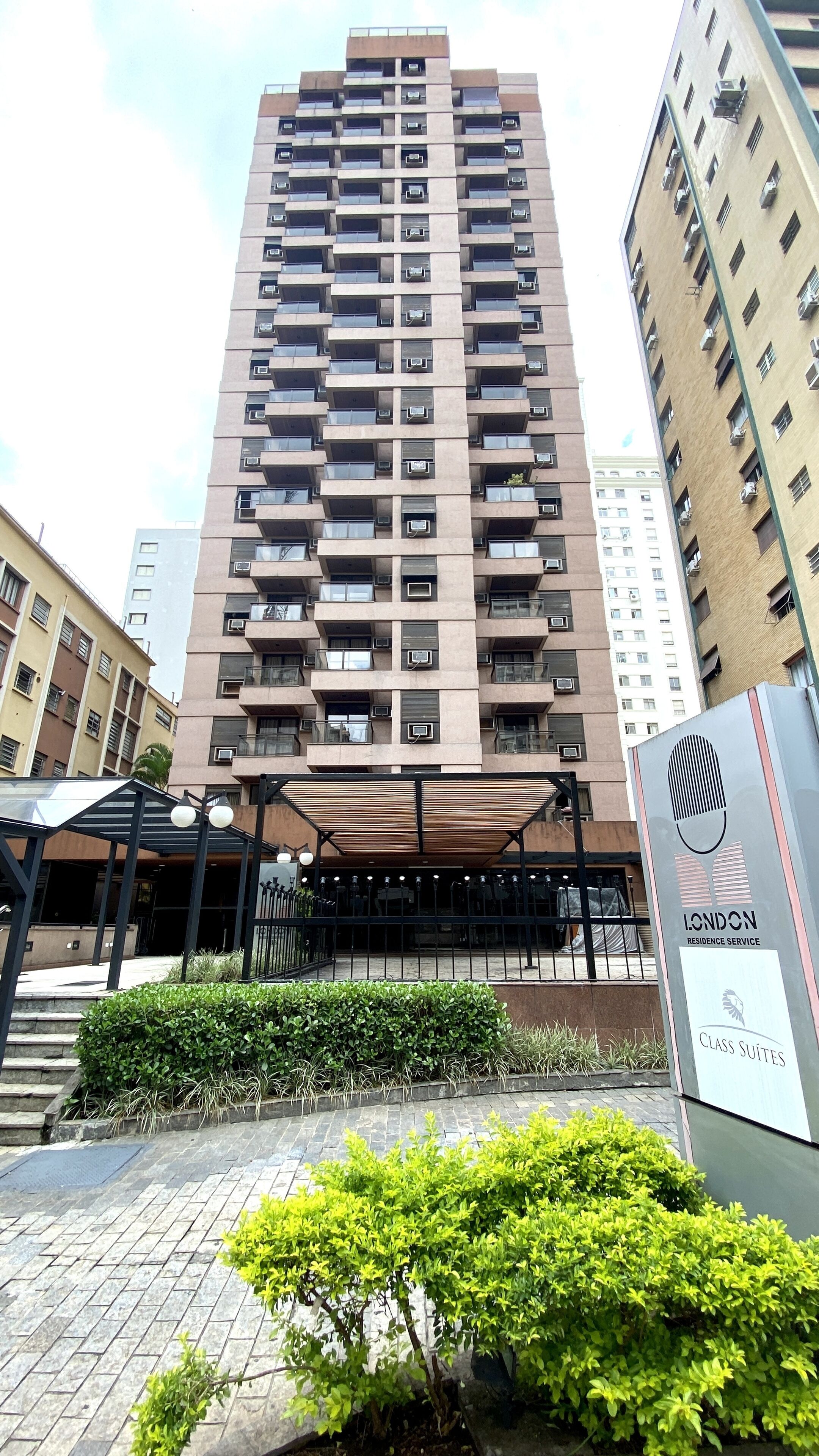 A high-rise building with multiple balconies and air conditioning units.