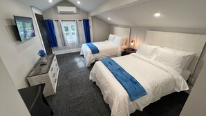 Een hotelkamer met twee bedden, een televisie, een bureau en een raam met gordijnen.