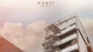 A modern Daric Hotel building with multiple floors, a prominent staircase, and a sign indicating a restaurant. - Daric Hotels (Atakum)