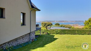 Une maison avec des fondations en pierre, un balcon et une vue sur la mer.