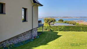 Una casa con fondamenta in pietra, un balcone e vista sul mare.