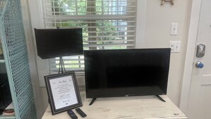 A white table with a black TV and a framed certificate. - Great One Room with Full Bath Guest House! (Darien)