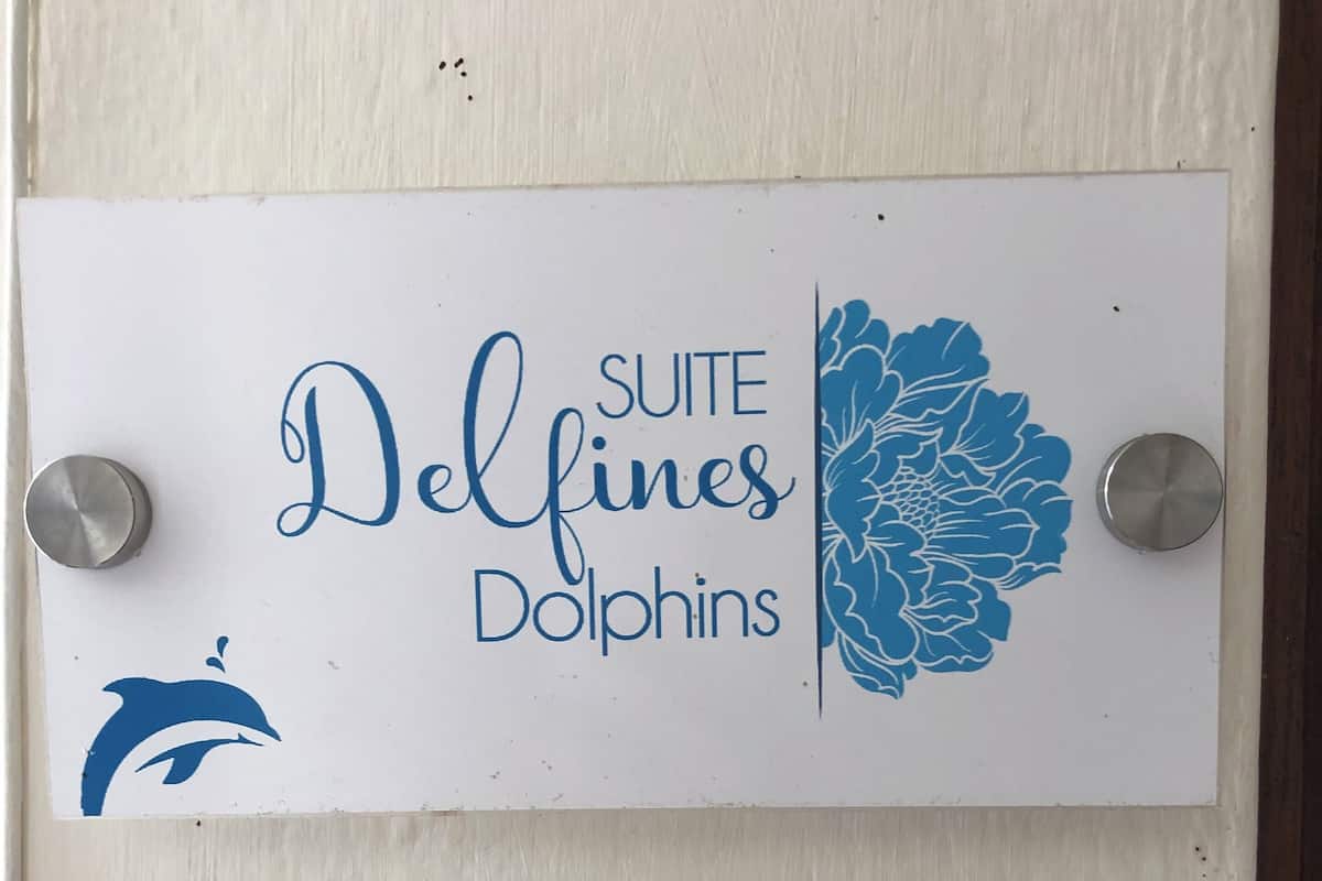 A sign with the text "Suite Delfines Dolphins" and a dolphin logo.
