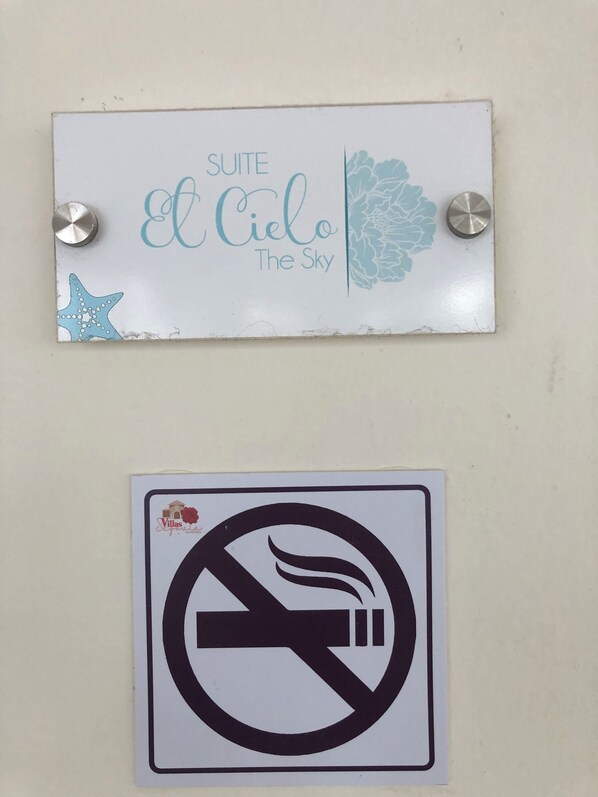 Letrero que dice 'Suite El Cielo The Sky' y un letrero de prohibido fumar.