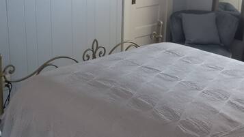 Une chambre à coucher avec un lit, une chaise et une porte.