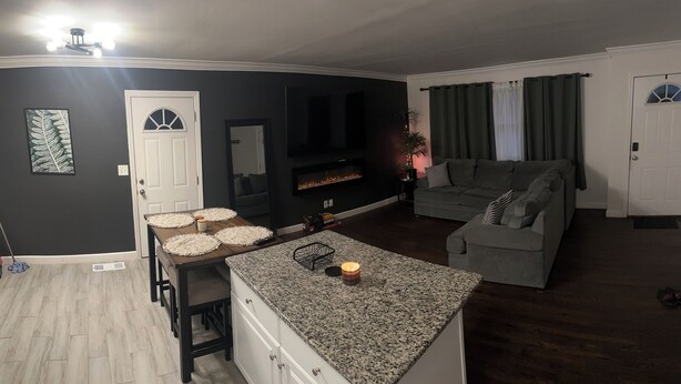 A modern kitchen with granite countertops, a built-in oven, and a dining area with stools. - Family-Friendly Home with Downstairs Suite (Decatur)