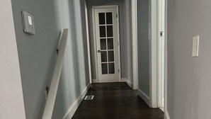 A narrow hallway with dark wooden stairs leading to a white door. - Family-Friendly Home with Downstairs Suite (Decatur)