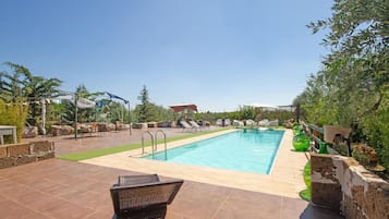 Relax by the serene pool surrounded by lush greenery and comfortable lounge chairs.