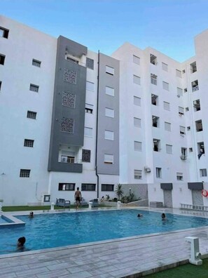 Enjoy a refreshing dip in the pool surrounded by a paved walkway and expansive views.