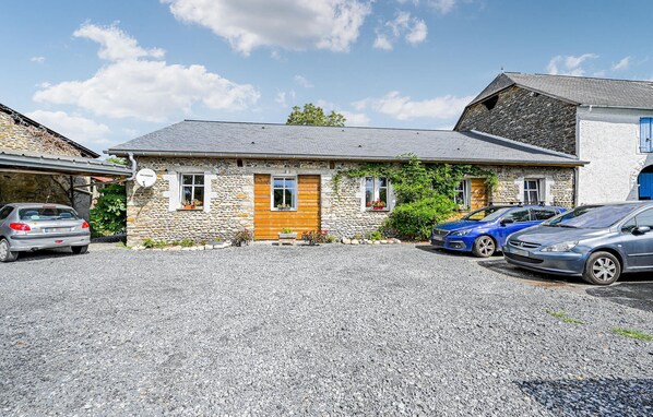 A stone building with a wooden door, two windows, and a gravel driveway. - Gorgeous home in Aren (Aren)