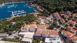 An aerial view of a coastal town with a marina, residential buildings, and a central square with a pool. - Awesome home in Korcula with WiFi (Korcula)