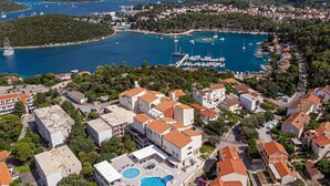 An aerial view of a coastal town with a marina, residential buildings, and a hotel with a rooftop pool. - Awesome home in Korcula with WiFi (Korcula)
