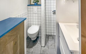 Een badkamer met een toilet, douche en bad.