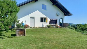 Una casa moderna con tetto spiovente, un piccolo portico e un prato curato.