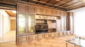 Un'ampia cucina con mobili in legno, forno a incasso e tavolo da pranzo in vetro.