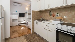 Una cocina moderna con armarios blancos, horno empotrado y un fregadero.