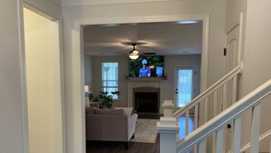 A spacious living room with a fireplace, a sofa, and a television. - Spacious New Home, Minutes to Augusta National! (North Augusta)