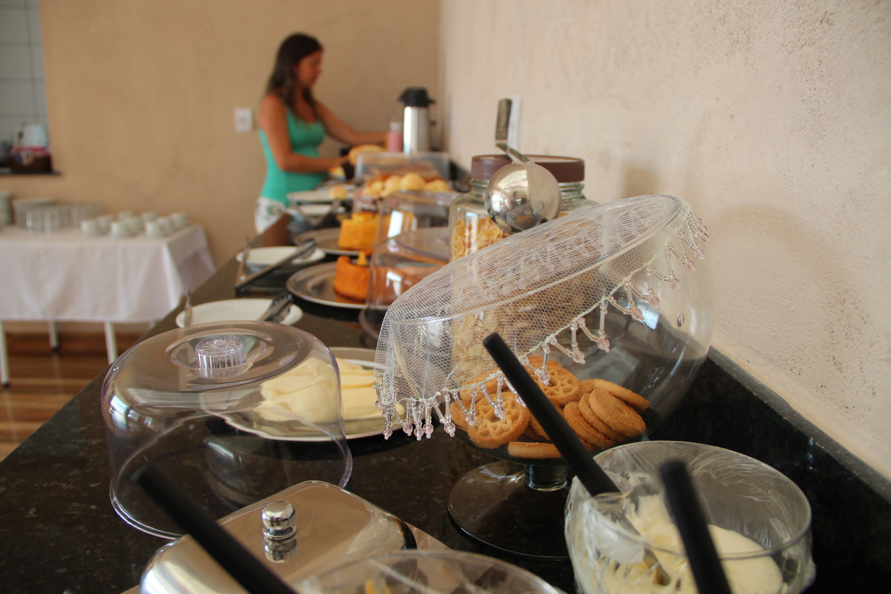 Mesa de buffet com diversos alimentos e utensílios de servir.