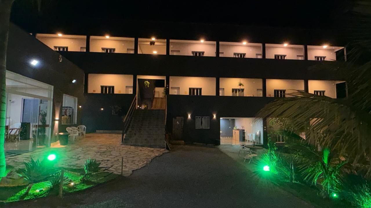 Ein mehrstöckiges Gebäude mit einer zentralen Treppe, Außenbereich zum Sitzen und einem gut beleuchteten Eingang.