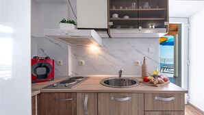 Een moderne keuken met een inbouwfornuis, een spoelbak en houten kastjes.