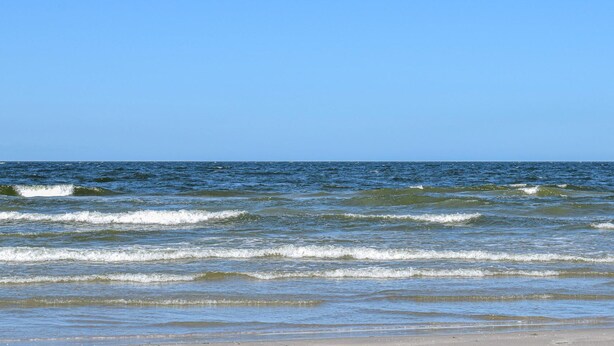 A beach with waves and a clear sky. - 2 bedroom beach front home in Wicie (Wicie)