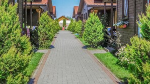 A pathway flanked by wooden buildings with balconies, leading to a central building with a yellow roof. - 2 bedroom beach front home in Wicie (Wicie)