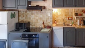 A compact kitchen with grey cabinets, a microwave, a toaster, a sink, and a dishwasher.