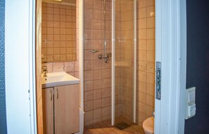 Bathroom features a shower enclosure and a sink with a tiled backsplash.