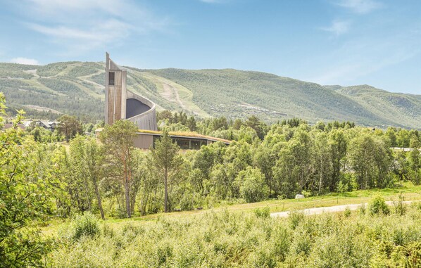 Situated in a lush valley, this unique retreat offers a serene escape amidst rolling hills and dense tree cover.