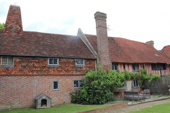 A traditional brick house with a tiled roof, a chimney, and a small doghouse. - Delightful 4BD Home Full of Flair Edenbridge Kent (Edenbridge)