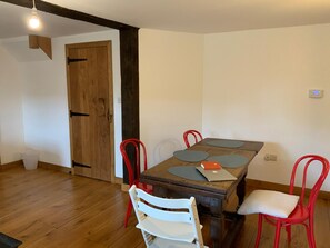 A dining area with a wooden table, four chairs, and a laptop on the table. - Delightful 4BD Home Full of Flair Edenbridge Kent (Edenbridge)