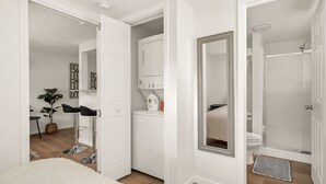 A modern bathroom with a shower, toilet, and a vanity with a mirror. - One bedroom duplex in desirable Park Hill (Fort Smith)