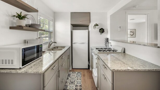 A modern kitchen with a built-in microwave, a stainless steel refrigerator, and a gas stove. - One bedroom duplex in desirable Park Hill (Fort Smith)