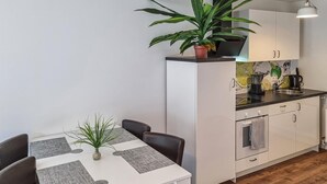 A compact kitchen with white cabinets, a black countertop, and a potted plant. - Amazing apartment in Passow OT Charlottenho (Passow OT Charlottenho)