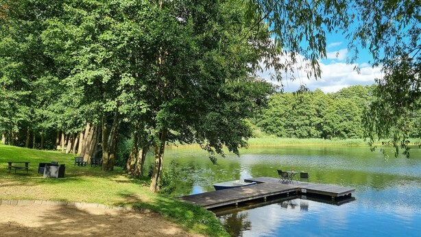 A lakeside park with a wooden dock, picnic tables, and benches. - Amazing apartment in Passow OT Charlottenho (Passow OT Charlottenho)
