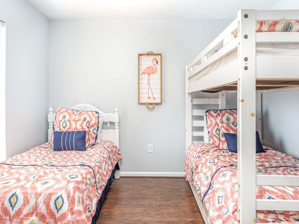 Una habitación con dos literas, una cama individual y un cuadro en la pared.