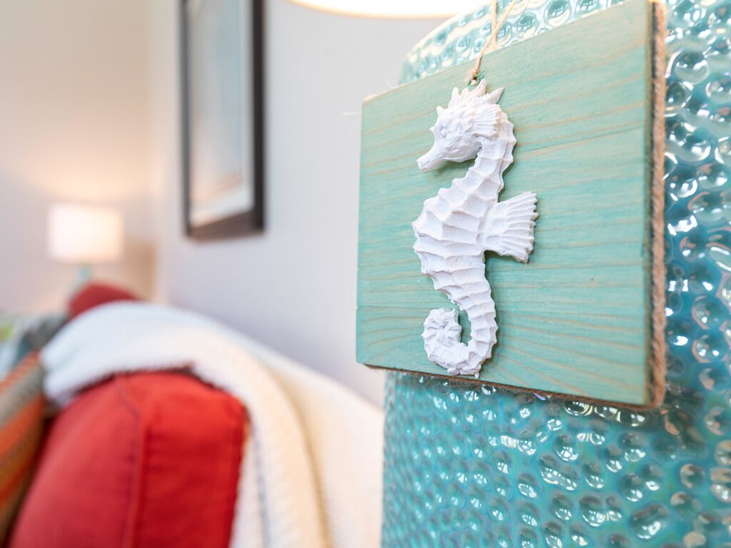 A seahorse decoration on a textured teal wall.