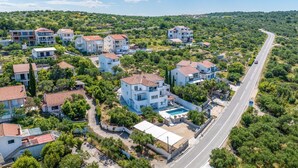 A residential area with modern houses, a swimming pool, and a road. - Cozy apartment in Murter with kitchen (Murter)