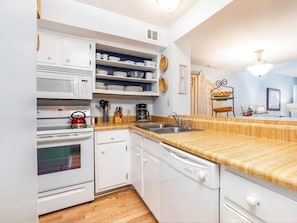 Kitchen area with microwave, oven, dishwasher, sink, and various appliances.