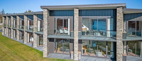 A modern multi-story building with large glass windows and stone pillars.