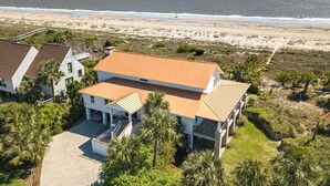 A two-story house with a wooden roof, surrounded by palm trees and a beach view. - Van Horne Villa by Tybee Vacation Rentals (Tybee Island)