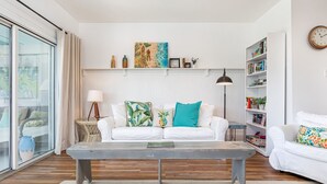 Una sala de estar moderna con un sofá blanco, una mesa de centro y una estantería.