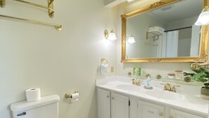 A bathroom with a toilet, sink, mirror, towel rack, and a hexagonal tile floor.