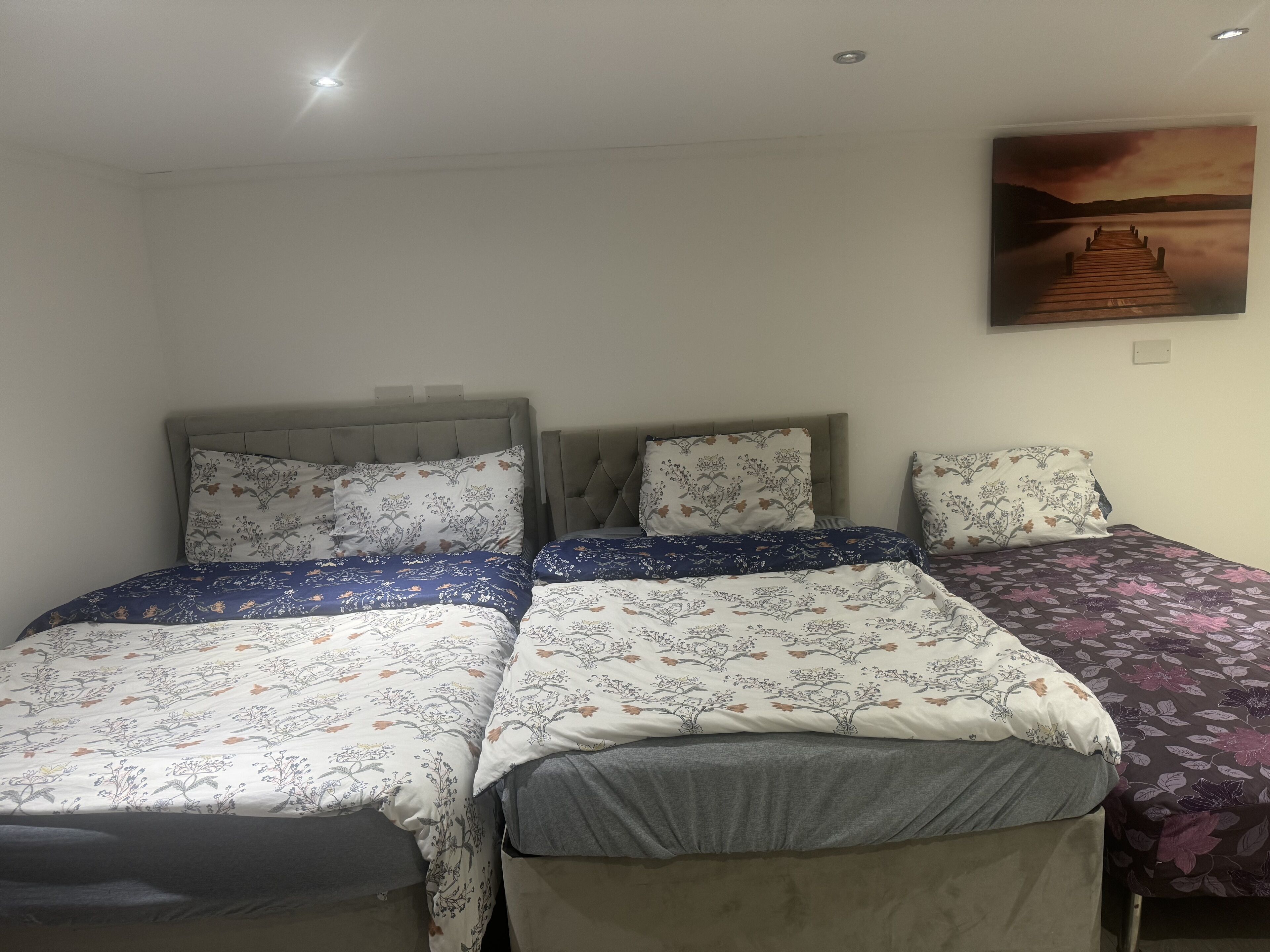 A bedroom with two beds, each with floral-patterned bedding and headboards.