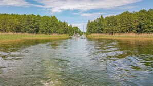 Ein ruhiger Fluss mit Booten, umgeben von dichtem Grün.
